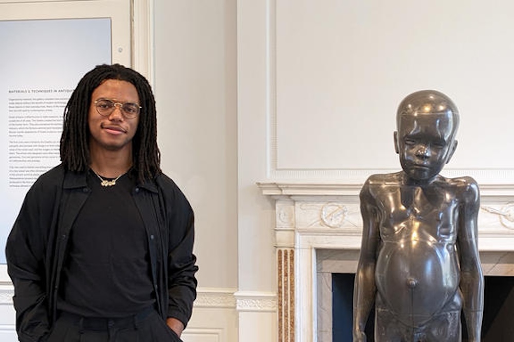 Anderson with a figurative sculpture in a gallery