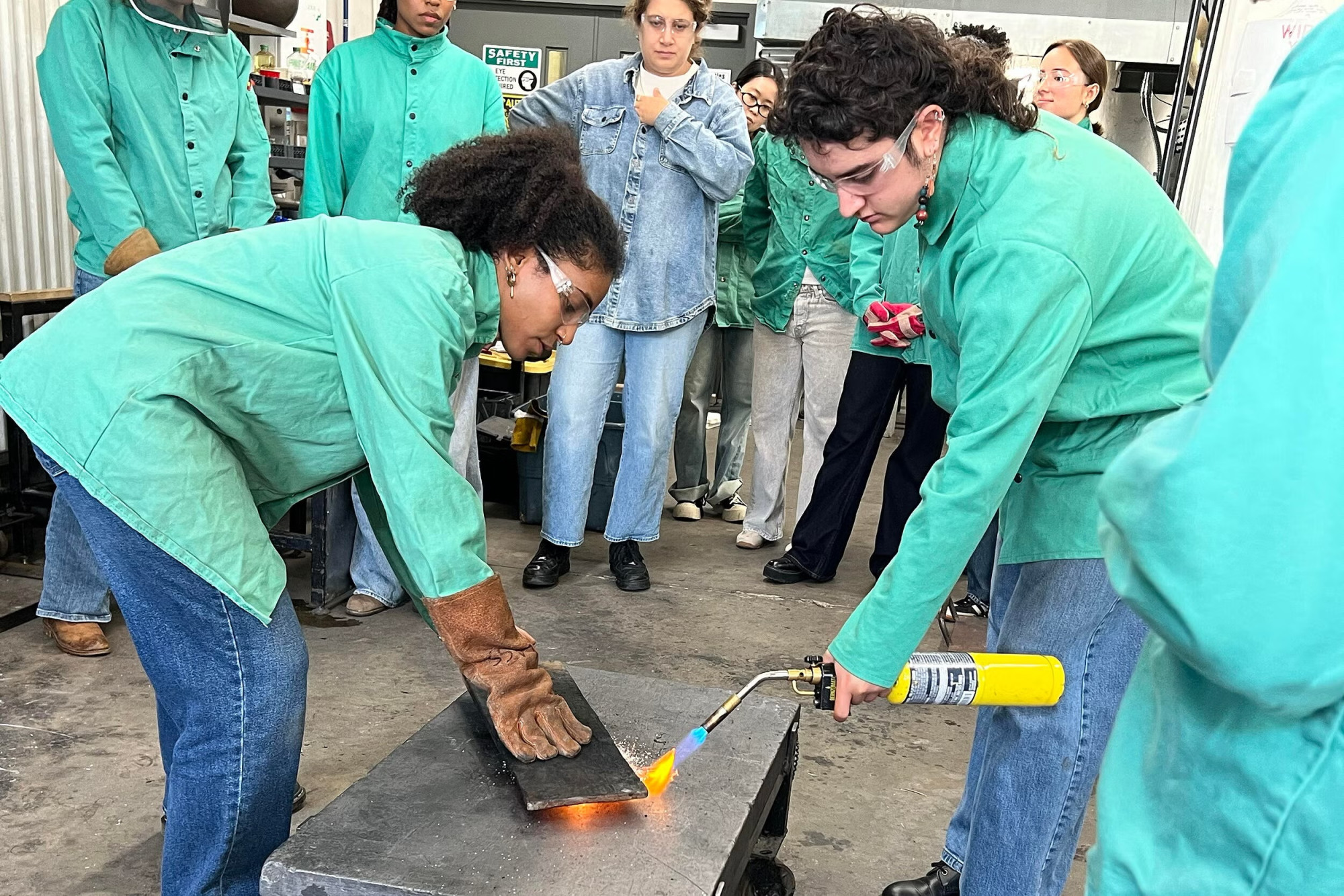 Two people working together on a glass object