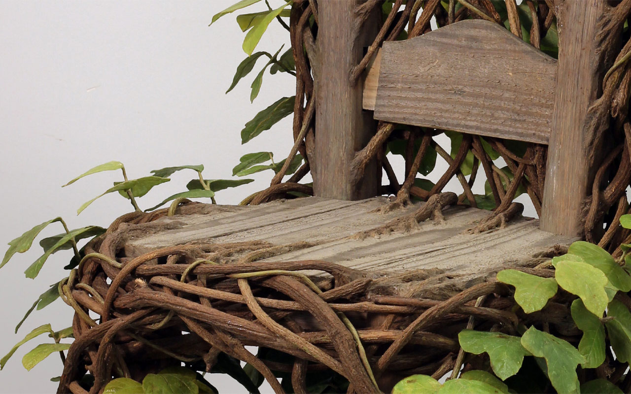 wooden chair with branches and leaves growing from it