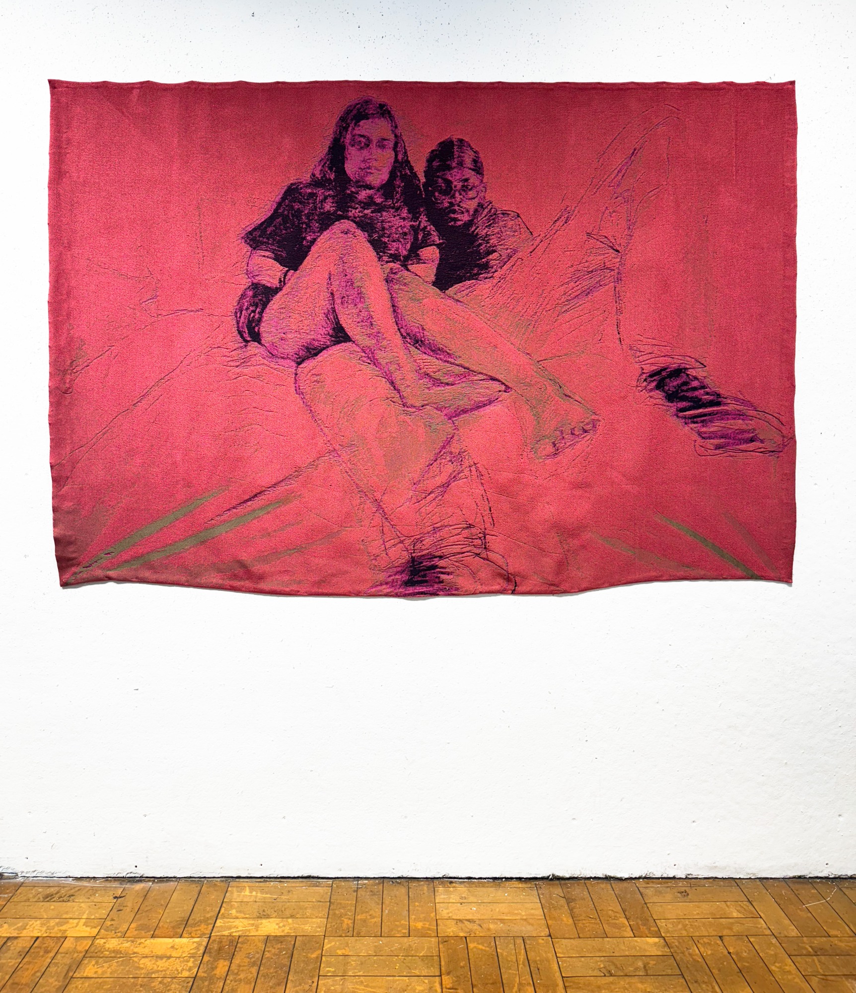 Red weaving depicting two people on a white wall